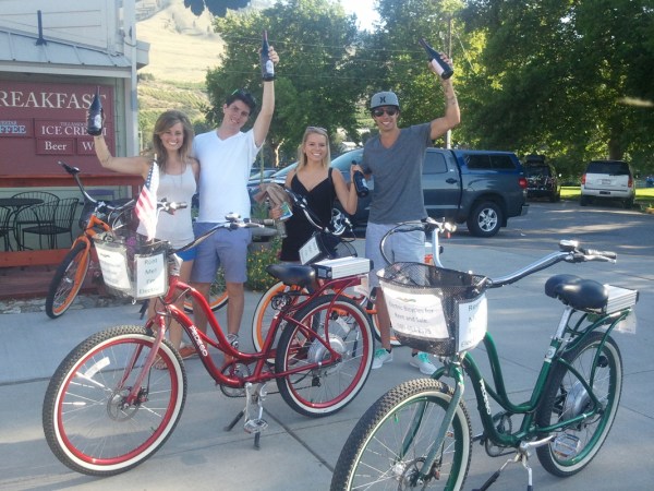 a man and woman riding on the back of a bicycle