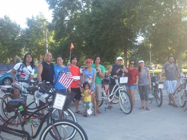 a group of people riding on the back of a bicycle