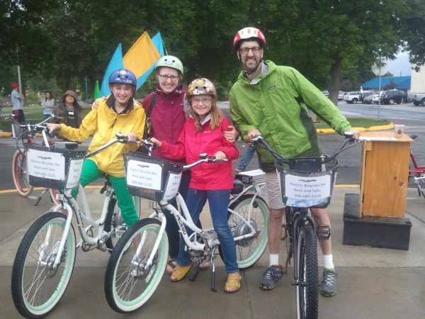 a group of people riding on the back of a bicycle