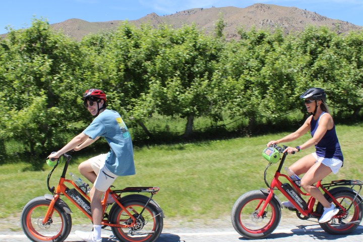 a group of people riding on the back of a bicycle